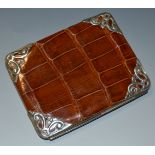 An early 20th century crocodile leather and silver coloured metal wallet,