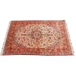 A Tafresh carpet, the madder field decorated with floral motifs in tones of red on a cream ground,
