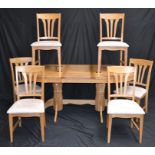 A modern dining table and six chairs, the table has a built in leaf extension,