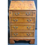 A small narrow yew bureau, fall front top, fitted interior, above three drawers,