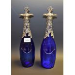 A pair of blue glass bottles, white metal mounts,