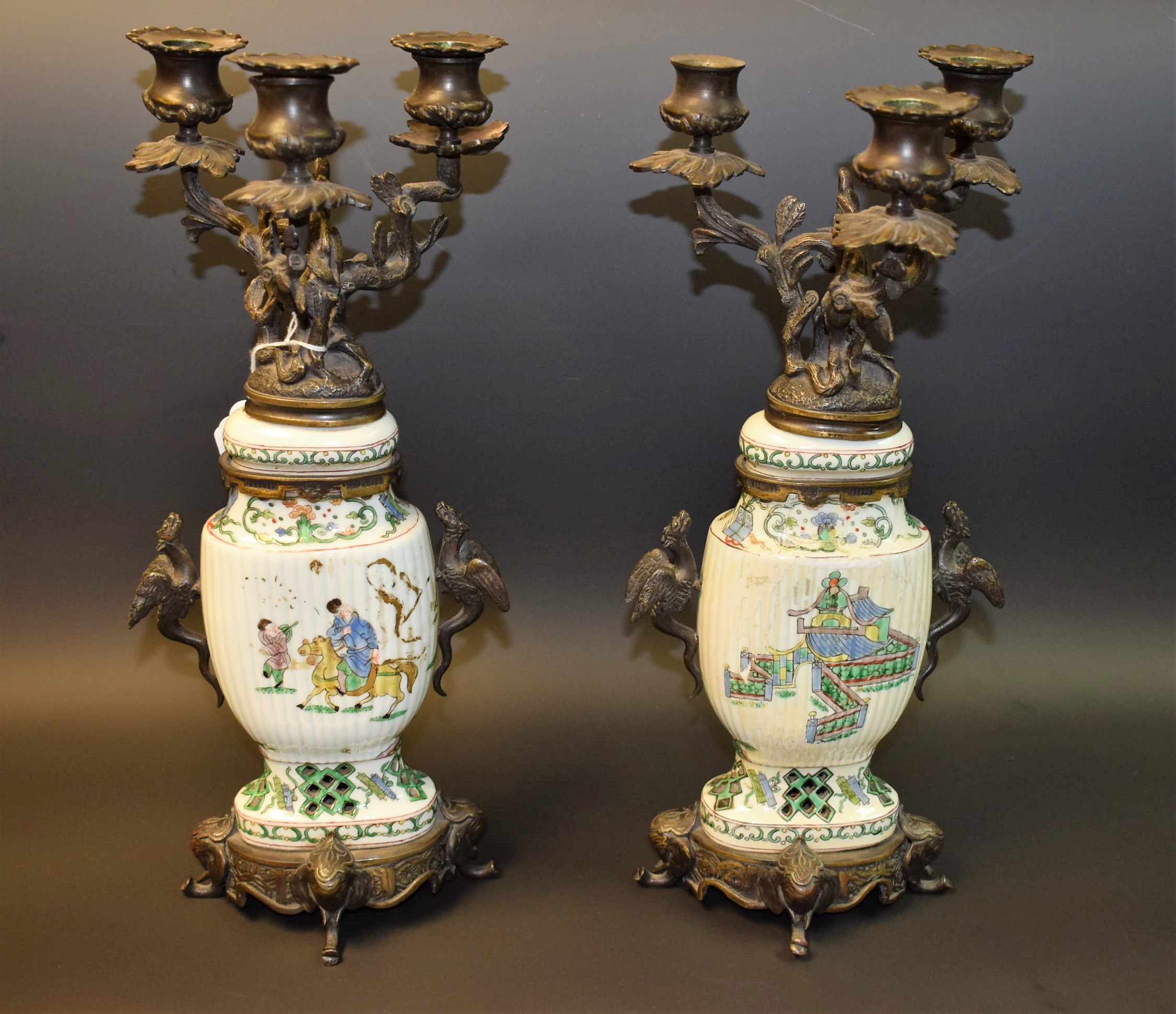 A pair of Chinese bronze and porcelain three light candleabra,