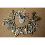 A silver charm bracelet, heart shaped locket; charms to include Noah's Arc, vintage car,