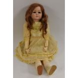 A Kammer & Reinhardt bisque head doll, with sleeping blue eyes, closed mouth, auburn wig,