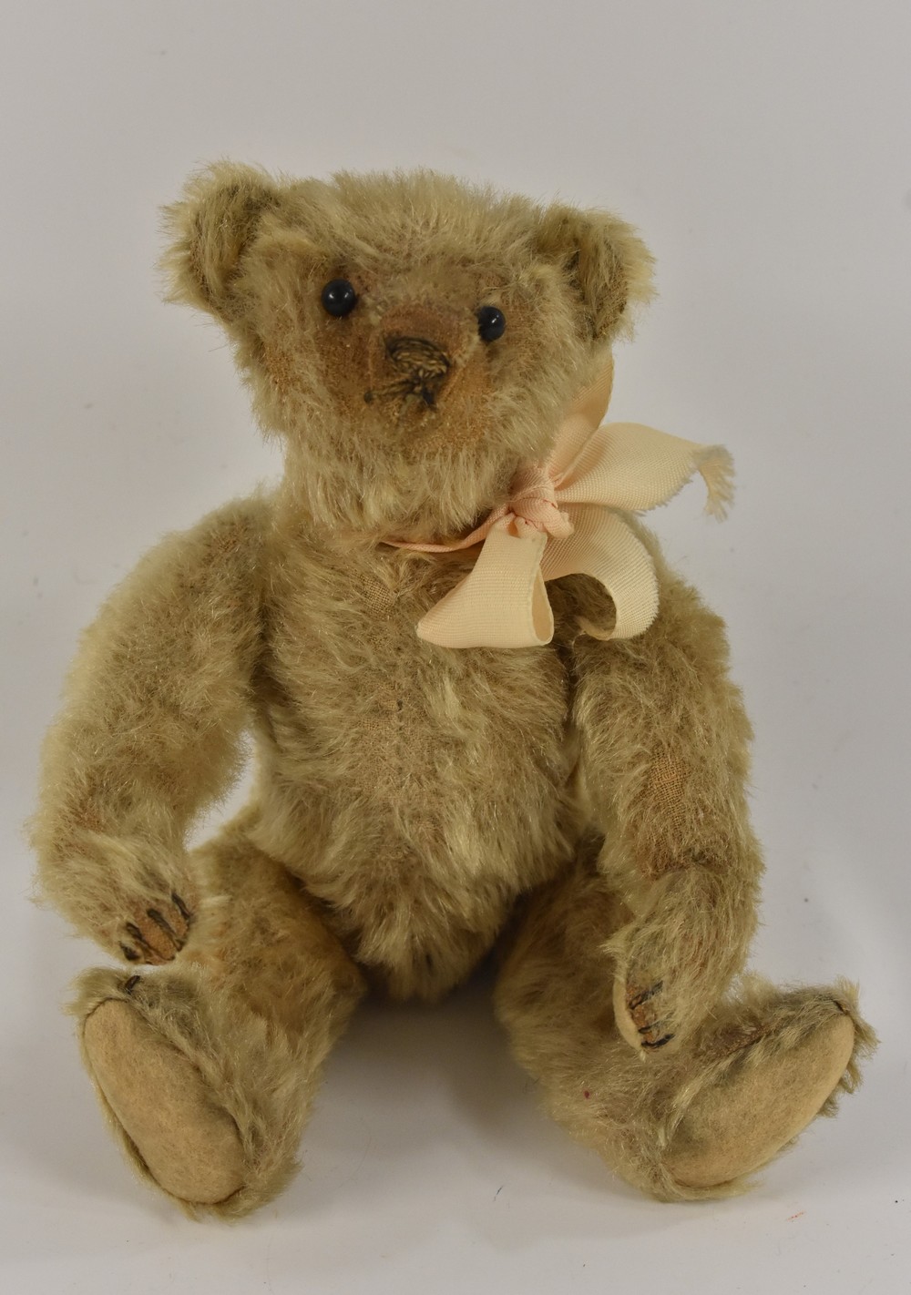 Steiff - an early 20th century bear, black ball button eyes, stitched nose, slight hump back,