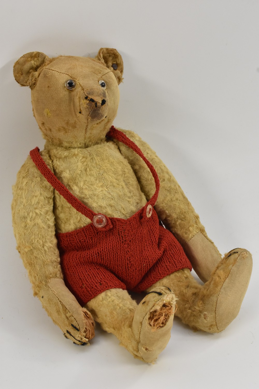 An early 20th century Steiff gold plush bear, tapering nose, glass eyes, centre seam body,