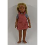 A Trendon Sasha doll, with fair hair, wearing a blue and white shirt, red pinafore dress,