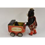 A Japanese S&E tin plate Royal Cub battery operated model Bear pushing a pram, tartan dungarees,