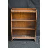 A 1940's oak floor standing bookcase, three-quarter gallery over three shelves, 103cm high,