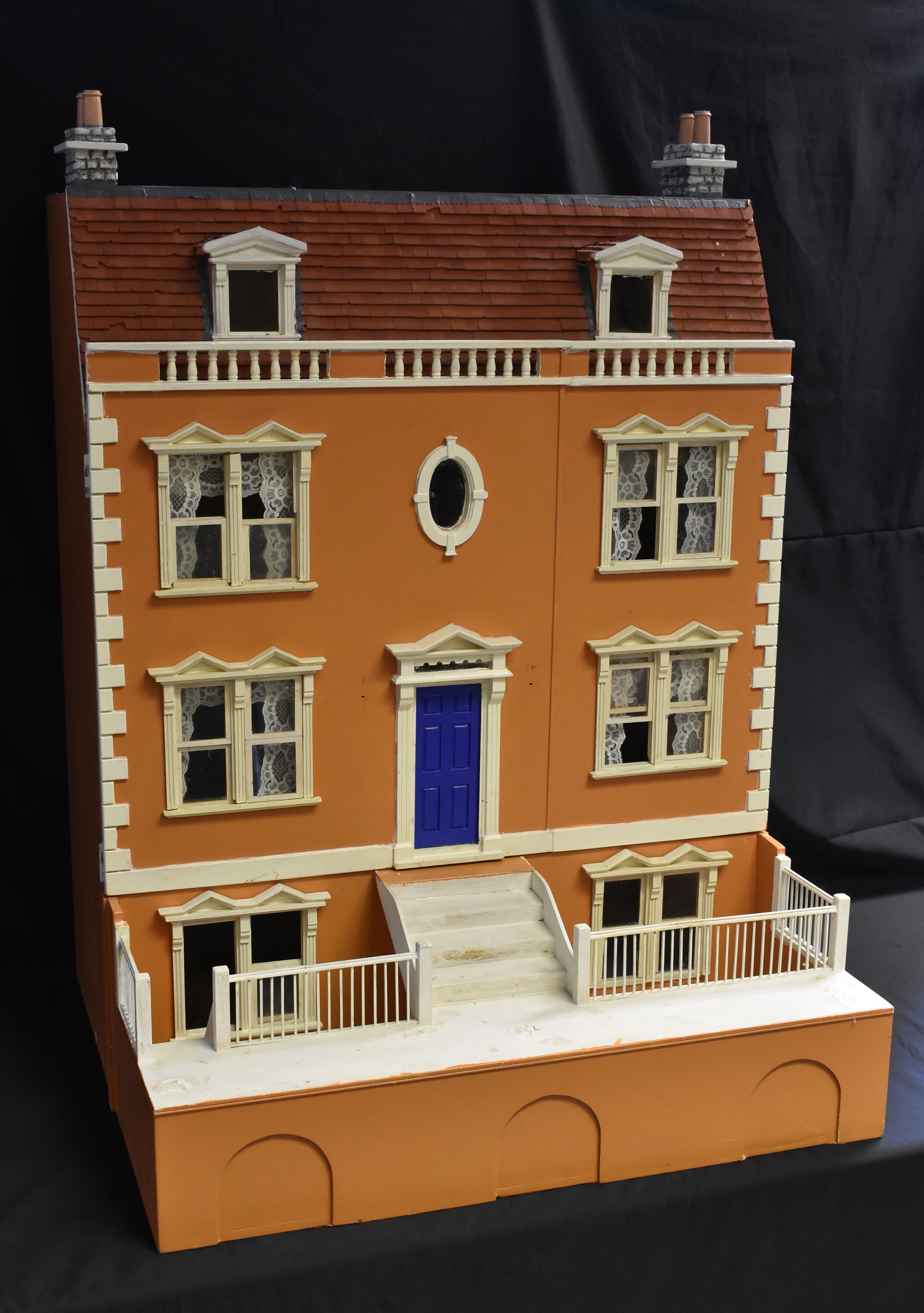 A wooden two section Dolls House, four storey main house with lift up hinged roof,