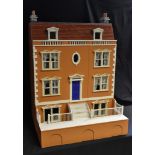 A wooden two section Dolls House, four storey main house with lift up hinged roof,