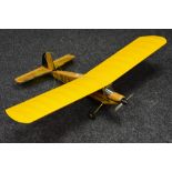 A Radio controlled balsa wood and paper single wing Airplane, wooden fuselage, yellow wings,