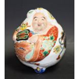 A Japanese Satsuma porcelaineous novelty, of a comic figure, painted in colourful polychrome,