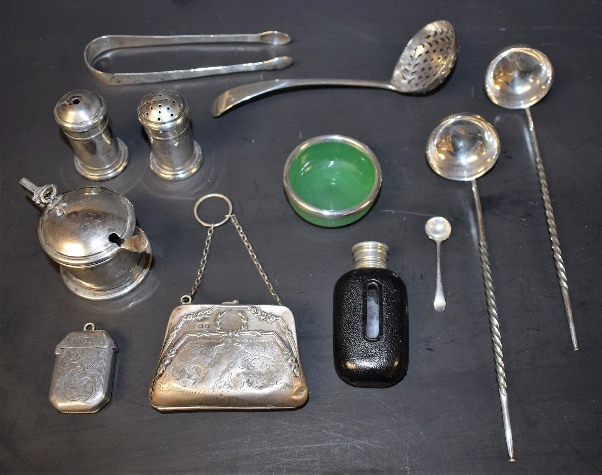 A three piece silver condiment set; a silver vesta case; a silver purse;