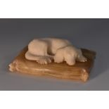 A 19th century alabaster model, of a King Charles spaniel, recumbent on a cushion,
