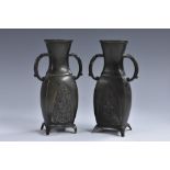 A pair of small Japanese patinated bronze flattened ovoid vases,