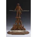 A 19th century cast iron walking stick stand, as a sailor, standing above a maritime trophy,