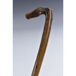An early 20th century Greek walking cane, the L-shaped handle carved with the head of a horse,