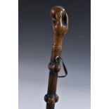 A 19th century folk art walking cane, the fruitwood pommel carved as a hand grasping a ball,
