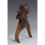 A Black Forest novelty lever-action nut cracker, carved as a gentleman wearing a cloth cap,