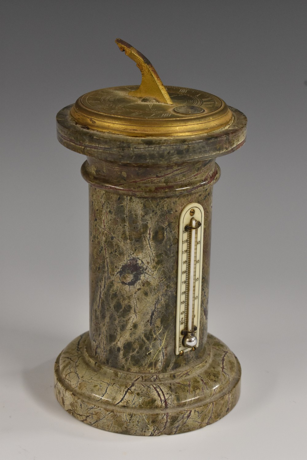 A 19th century gilt brass mounted serpentine desk top sundial, compass and thermometer, as a column,