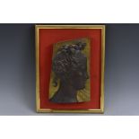 A hardwood panel, carved in the manner of a Classical sculptural fragment,