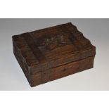 A Black Forest rectangular box, carved as a bark bound by straps, hinged cover centred by a flower,
