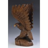 A 19th century style carving, of an eagle, perched on a rocky outcrop,