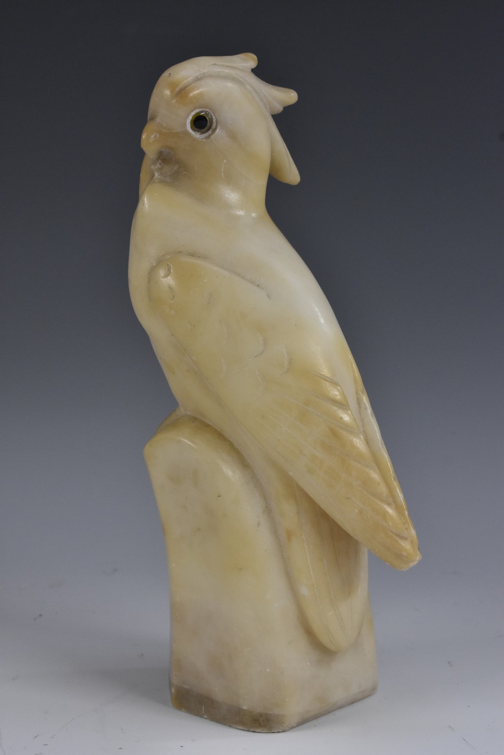 A 19th century carved alabaster model of a cockatoo, glass eyes, 21.