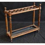 A late Victorian oak country house sixteen-division stick stand, spherical finials to angles,