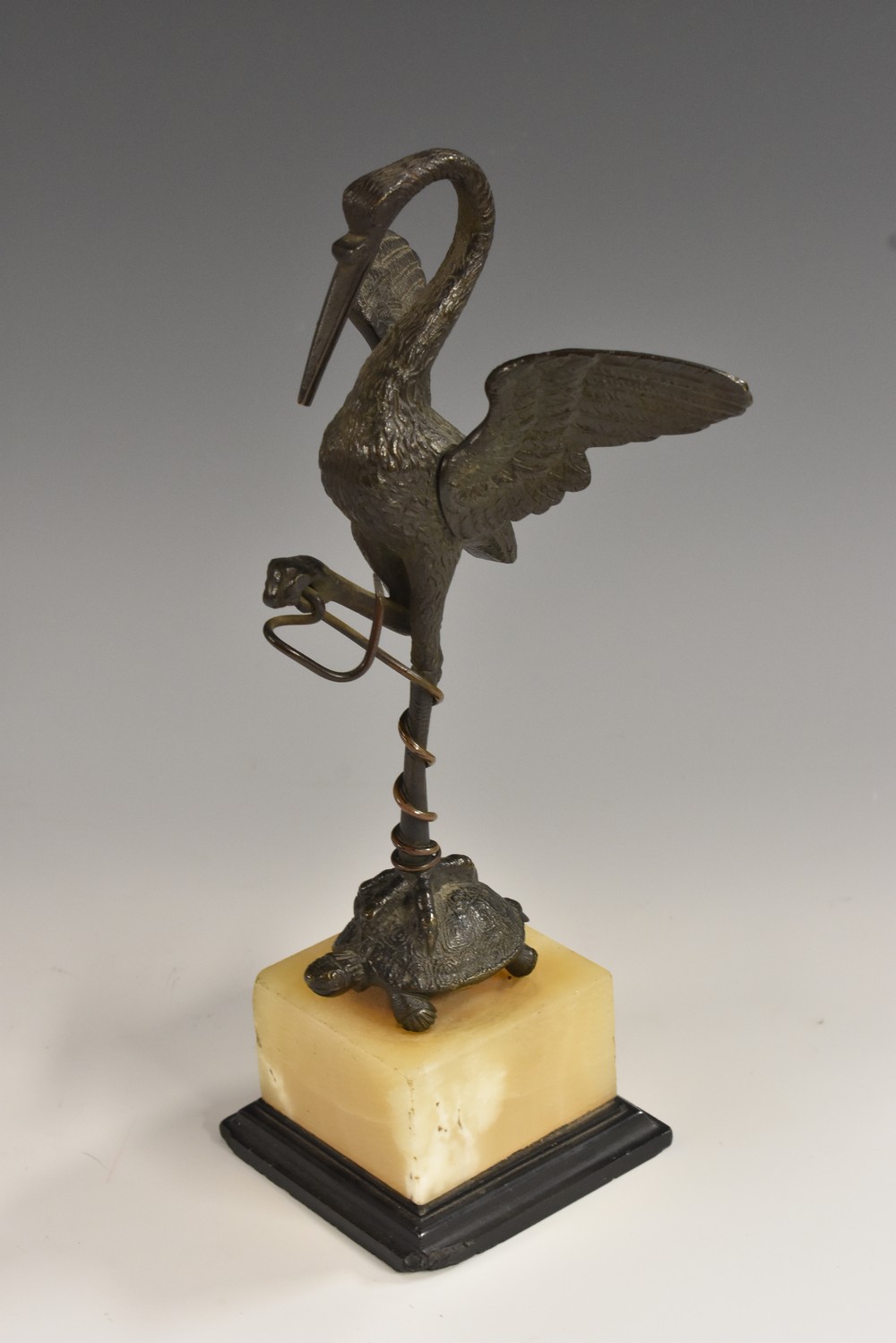 A 19th century dark patinated bronze pocket watch stand, as a stork on the back of a tortoise,