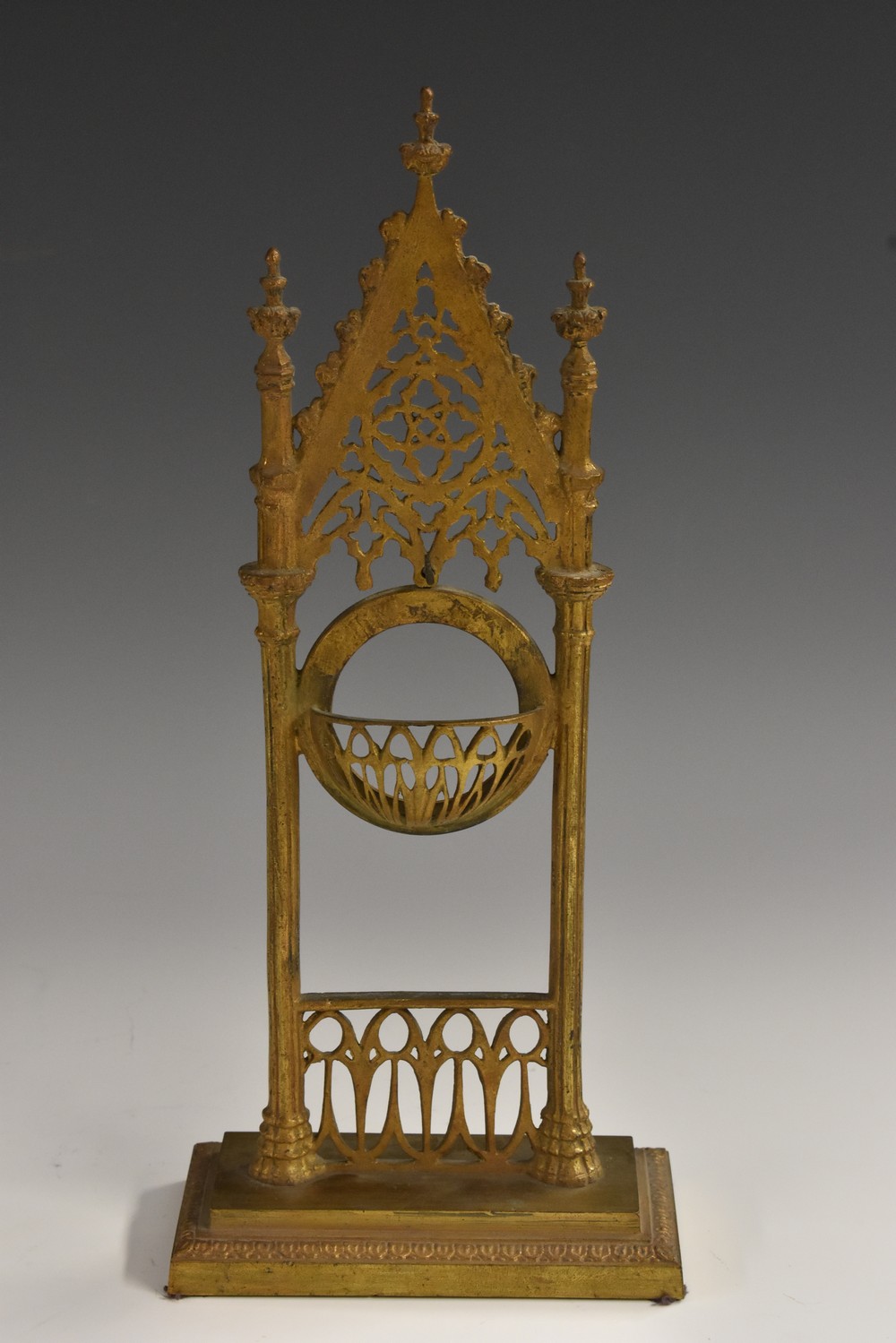 A 19th century Gothic Revival gilt metal pocket watch stand, pierced with tracery, rectangular base,