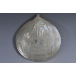 A Colonial mother of pearl pilgrim shell, carved in relief with the Flight into Egypt,