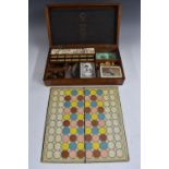 A late Victorian mahogany games box, hinged cover enclosing an arrangement of compartments,