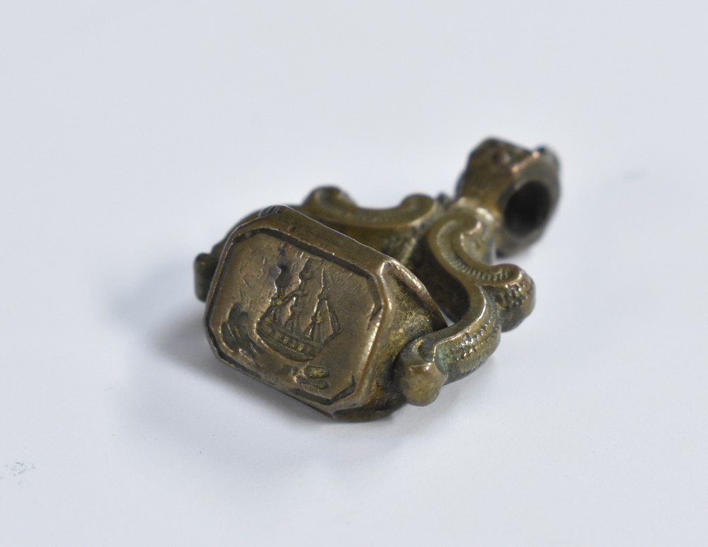 A 19th century brass triform swivel fob seal, the intaglio matrices as a ship,