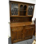 A priory style oak dresser two lead glazed cupboards to top,