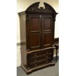 A contemporary Indonesian hardwood armoire style wardrobe, carved arched superior structure,