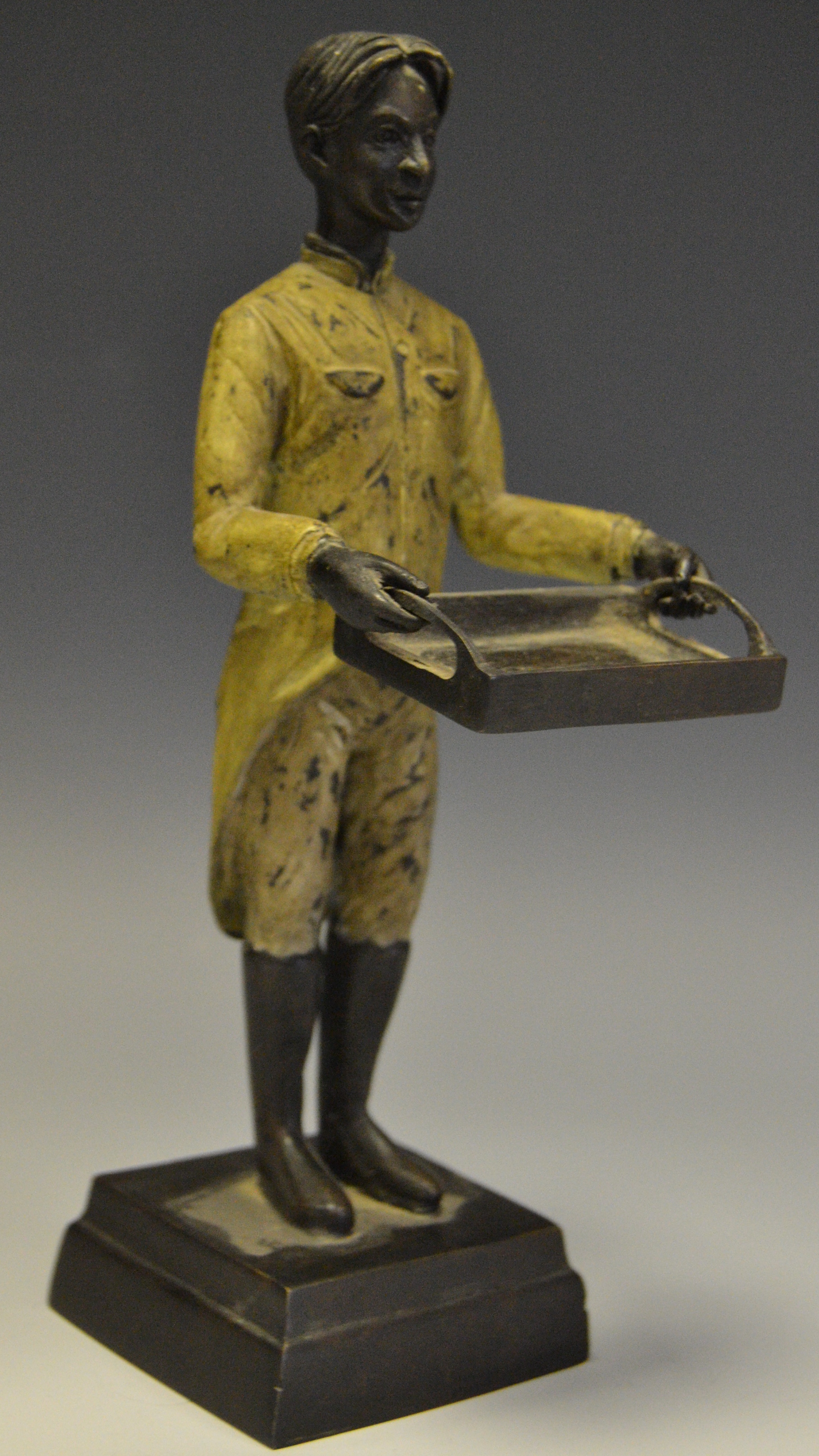 A contemporary cold painted bronze of a footman carrying a tray.