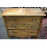 An oak chest of three drawers, oversailing top, brass batwing escutcheons, swing handles,