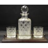 A whisky companion set comprising a decanter and two tumblers on a brass galleried stand