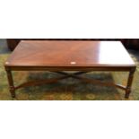 A contemporary mahogany coffee table, fluted supports, curved X-frame stretcher,