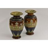 A pair of Doulton Lambeth ovoid vases, applied with forget-me-nots and scrolls on a tan ground,