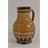 A Doulton Lambeth stoneware Mask Jug, of baluster form with silver-mounted rim,