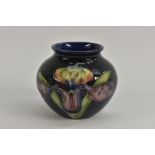 A Moorcroft Orchid pattern ovoid vase, tube lined with large flowerheads, on a cobalt blue ground,