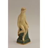 A Royal Worcester bisque figure, The Golden Slippers, female nude seated on a moss green pillar,