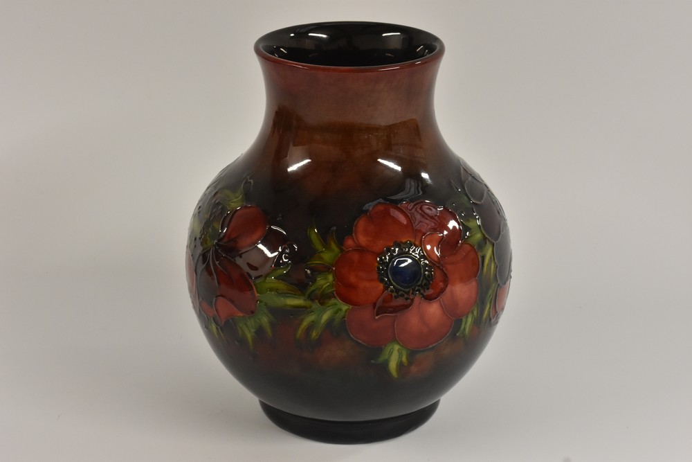 A Moorcroft Poppy pattern vase, tube lined with large flowers and foliage, on a flambe ground,