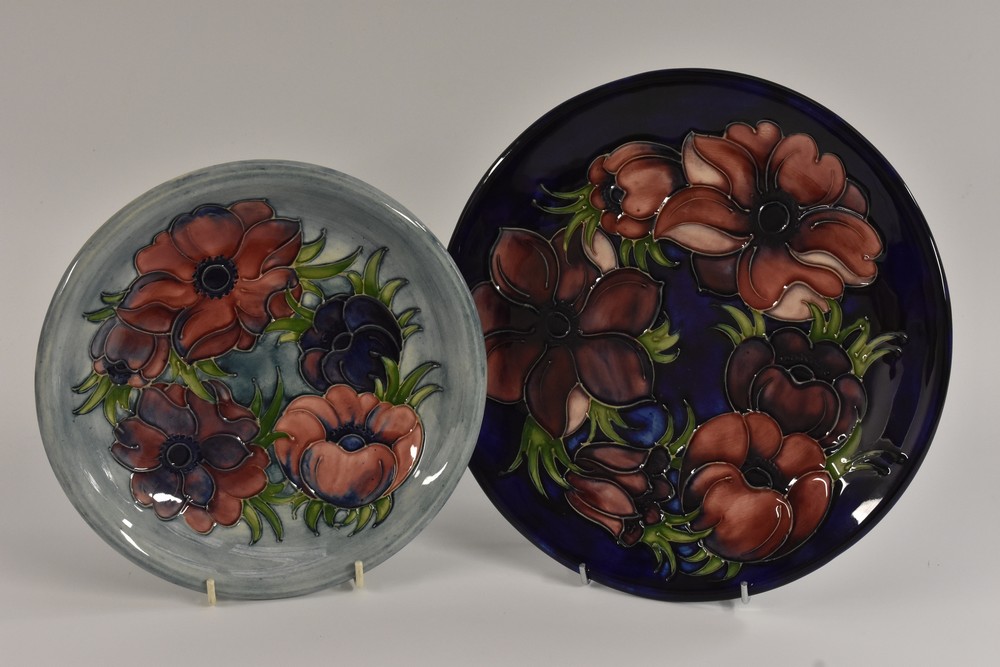A Moorcroft Anemone pattern wall plate, with blue and red flowers on a mottled blue ground,