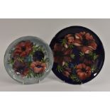 A Moorcroft Anemone pattern wall plate, with blue and red flowers on a mottled blue ground,