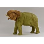 A large Royal Dux model of an elephant, trunk raised, in green and brown, 35cm high,
