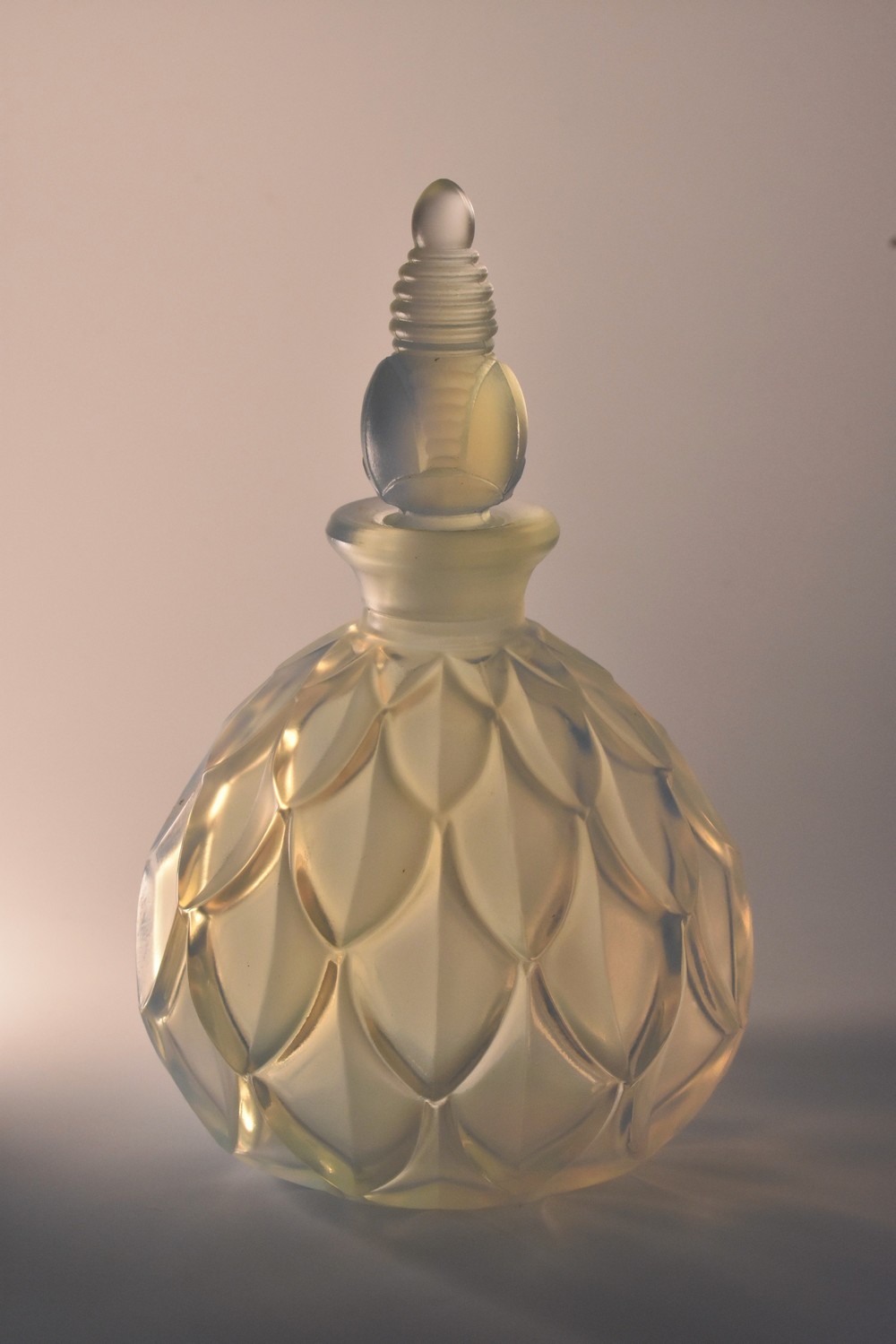 A Sabino opalescent glass scent bottle and stopper, moulded in relief with overlapping leaves,